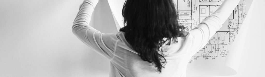 Woman showing building blueprint on the wall